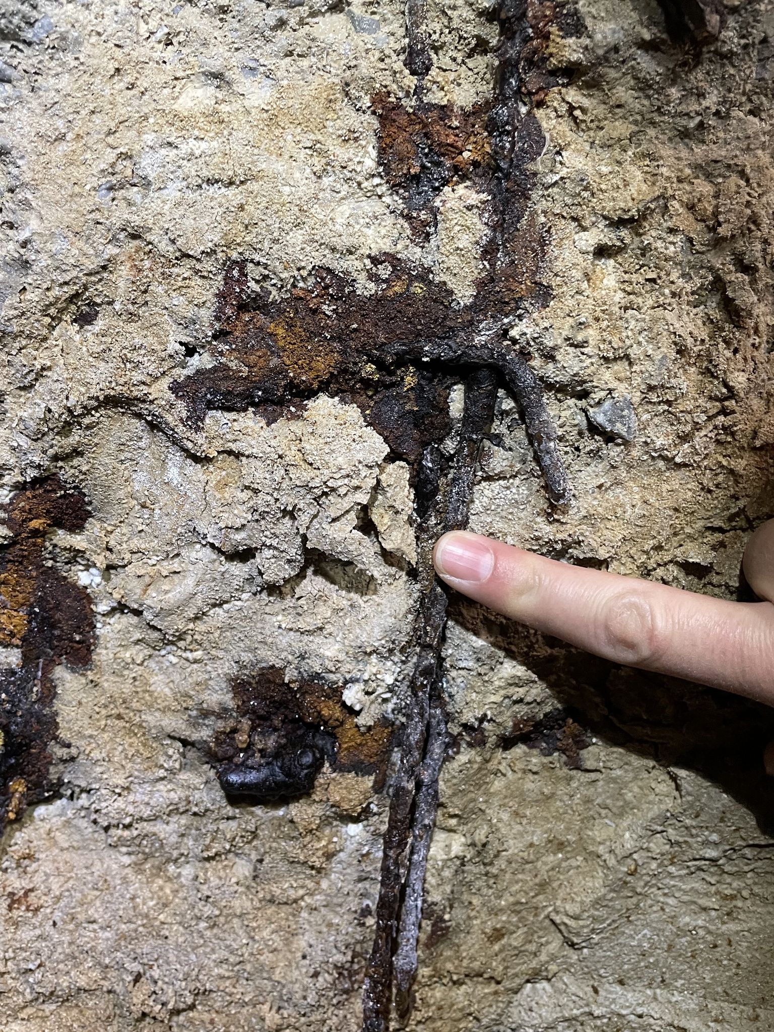 Stark korrodierte Bewehrungsgitter in einer Spritzbetonwand - die wolkenartige Mobilisation von Eisen ist idikativ für den Korrionsmechanismus.